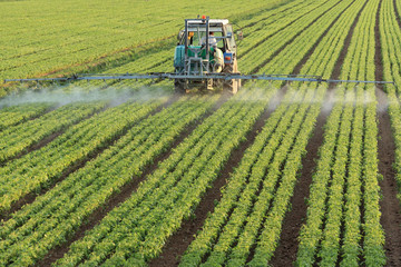 farming tractor spaying a field