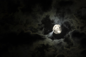 Full moon and eerie white clouds against a black night sky