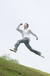 © Paylessimages - 丘の上をジャンプする男性