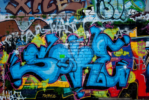 Graffiti detail on the textured brick wall © sardinelly