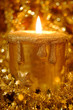 Golden burning candle surrounded by golden starts and sparkles