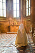 Praying nun inside the Abbey of Mont St. Michel, France