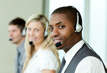 Businesspeople with headsets smiling at the camera