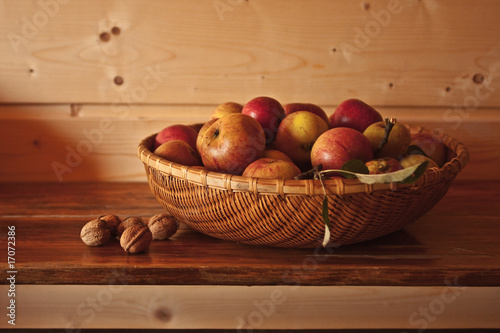 koszyk-z-jablkami-i-orzechy-wloskie-na-drewnianym-stole
