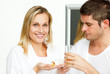 © WavebreakMediaMicro - Beautiful woman holding pills and man drinking orange juice