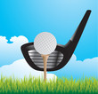 Golf ball on tee with club on grass
