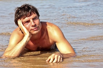 Young guy relaxing in the water contemplating