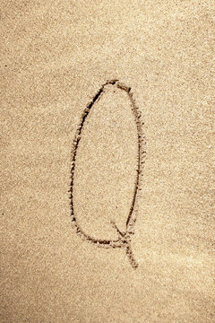Alphabet letter Q handwritten in sand