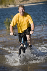 man riding bike in water