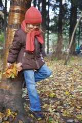 cute little girl standing near the tree in the park