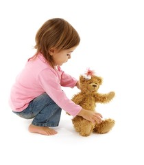 Wall Mural - cute little girl with her toy studio shot on white