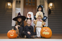 Children In Halloween Costumes With Pumpkins