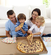 © WavebreakMediaMicro - Young family eating pizza in living-room