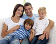 © WavebreakMediaMicro - Smiling young family sitting on sofa
