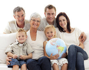 Wall Mural - Big family on sofa holding a terrestrial globe