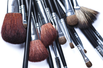 Cosmetic powder and black brushes isolated