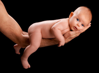 new born baby in fathers hand