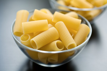 Raw pasta in glass bowl