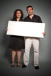 © FrankBoston - Cheerful couple holding a blank sign