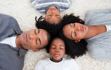 Wall Mural - Afro-American family sleeping on floor with heads together