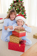 © WavebreakMediaMicro - Happy brother and sister holding Christmas presents