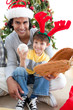 © WavebreakMediaMicro - Close-up of a father and son with christmas presents