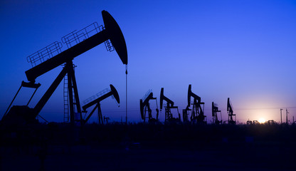 Silhouette of oil pump jacks with sunset