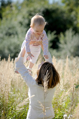 Wall Mural - Young mother holding her baby