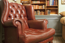 Old Style Armchair In Front Of Bookshelves
