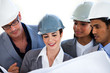 © WavebreakMediaMicro - International architects studying a blueprint