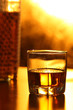 Glass of whiskey and ice on brown bar counter
