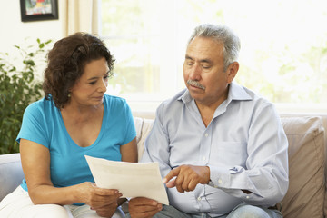 Senior Couple Studying Financial Document At Home