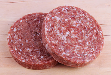 Two frozen hamburger patties on wooden background