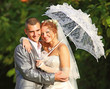 The groom the bride and a white umbrella