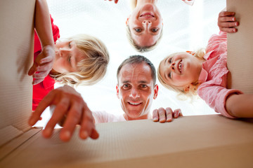 Wall Mural - Cheerful family unpacking boxes