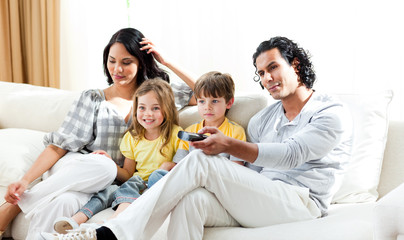 Wall Mural - Smiling family watching TV