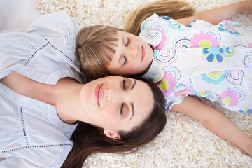 Wall Mural - Attractive mother and her daughter lying on the floor