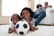 © WavebreakMediaMicro - Little boy and his sister holding soccer ball
