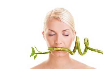 Beautiful young woman with a bamboo plant .