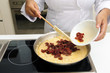 Chef cooking risotto adding dried tomato