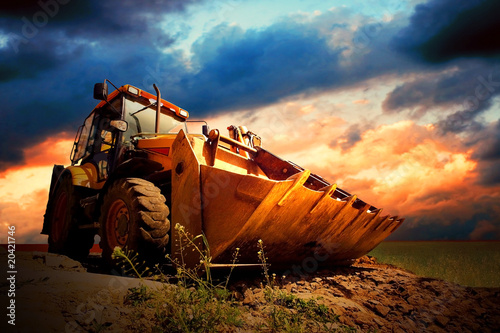 Cuadros en Lienzo Tractor amarillo en el cielo de oro surise