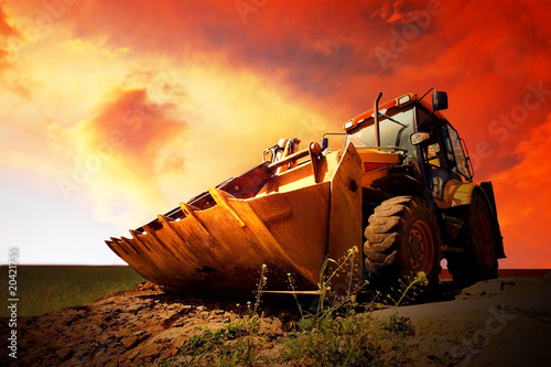 Fényképezés Yellow tractor on golden surise sky