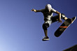 Un patinador está en el aire, realizando un truco en una rampa. Concepto de emoción y adrenalina, ya que el skater es capturado en una pose dinámica, mostrando su habilidad y atletismo.