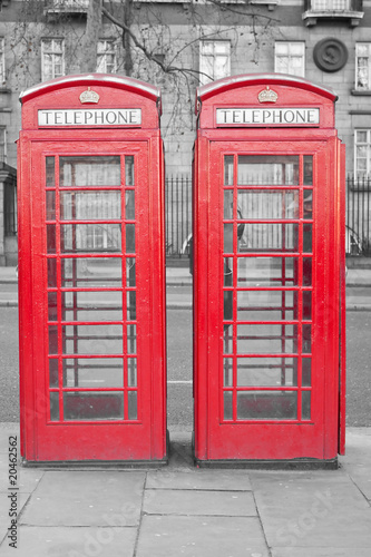Plakat na zamówienie Two typical London red phone cabins with a desaturated backgroun