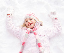 Girl Laying On Ground Making Snow Angel