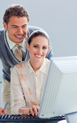 Attentive businessman helping his colleague work at a computer