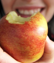 Smiling Woman Biting An Apple
