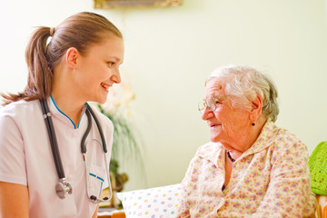 A caring doctor  and an elderly sick woman talking