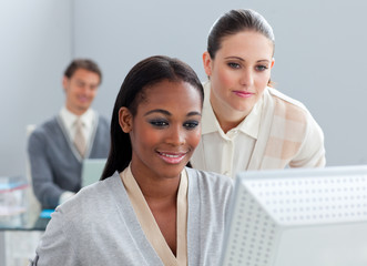 Portrait of two radiant businesswomen working at a computer