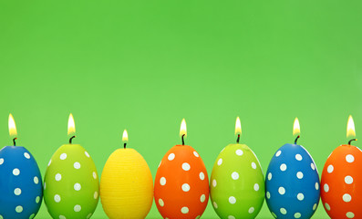 Poster - Easter egg candles on green background